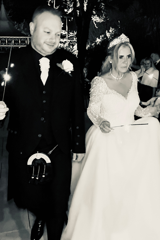 Black and white wedding content image of bride and groom holding sparklers during evening celebrations captured by Effortless Ivory Weddings