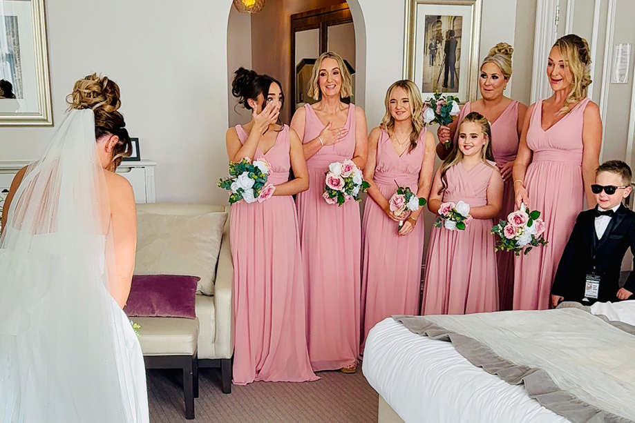 Emotional bridesmaids reacting to the bride’s wedding dress reveal during bridal preparations captured by Effortless Ivory Weddings