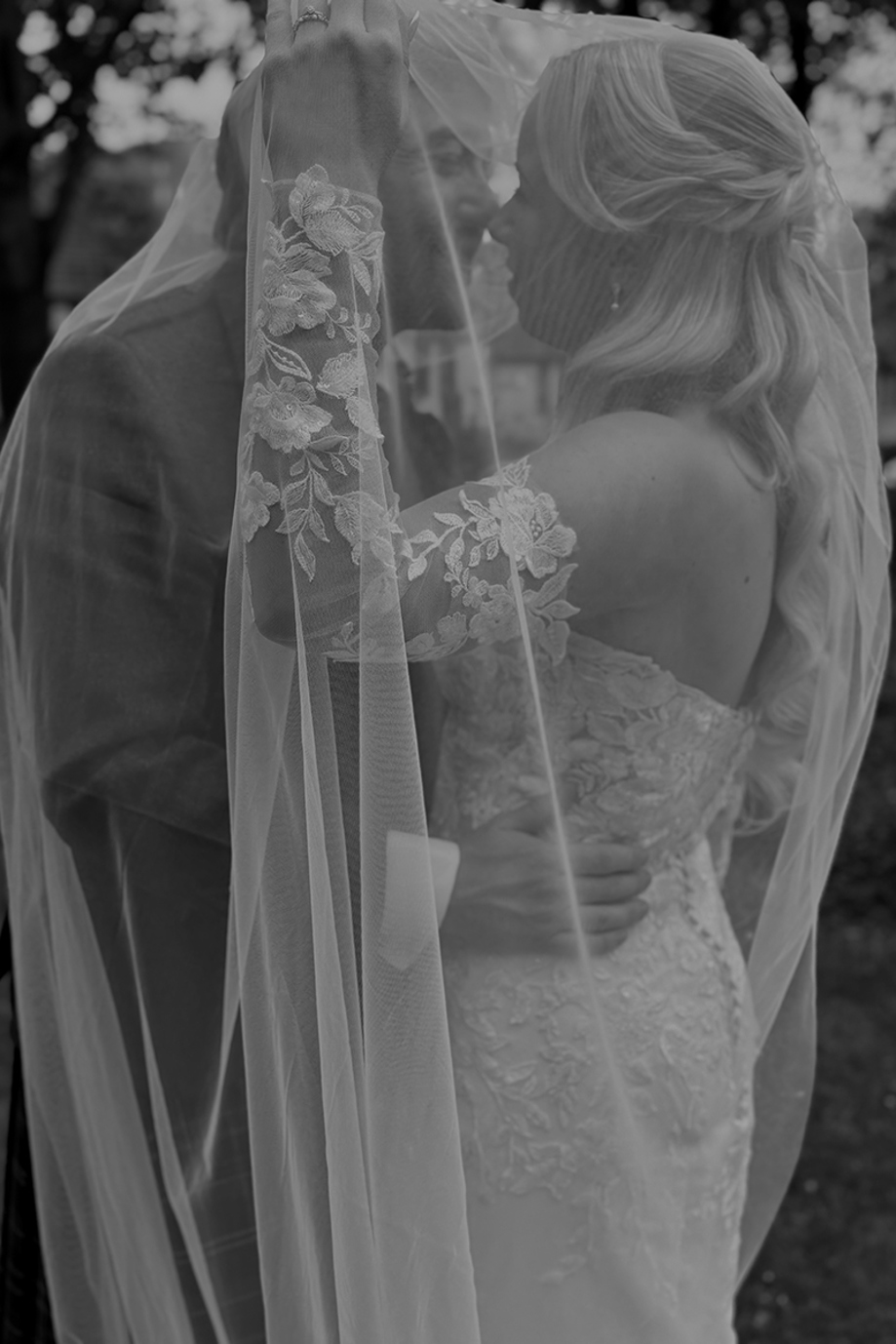 Black and white wedding content image of bride and groom kissing beneath the bride’s veil captured by Arauthentic Moments