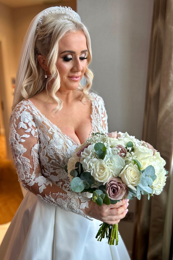 Bridal portrait showing a bride holding a white and blush rose bouquet during wedding preparations by Arauthentic Moments