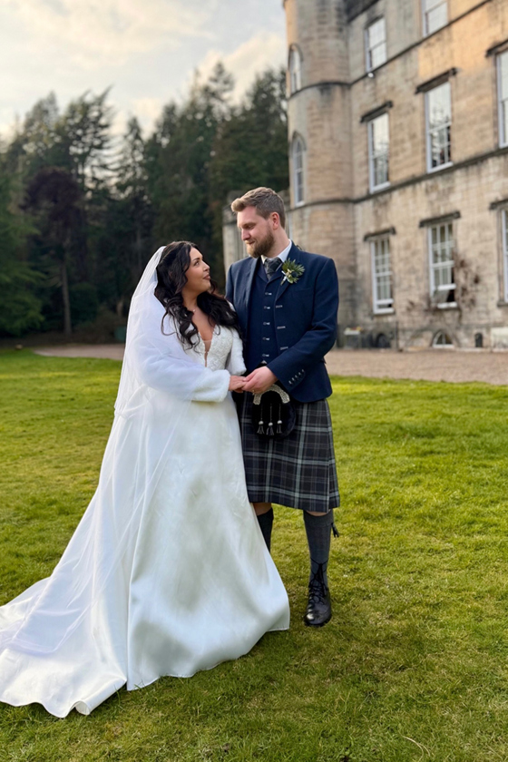 Bride and groom standing together outside a Scottish castle wedding venue in a romantic wedding portrait by Arauthentic Moments