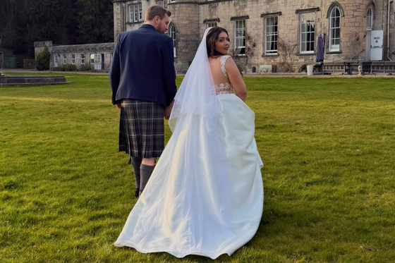 Bride and groom walking across the grounds of a Scottish castle wedding venue captured by Arauthentic Moments