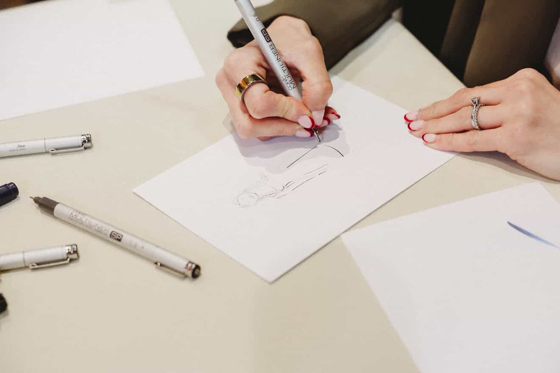 Close-up of Colleen sketching a personalised live wedding guest illustration using pen and paper.