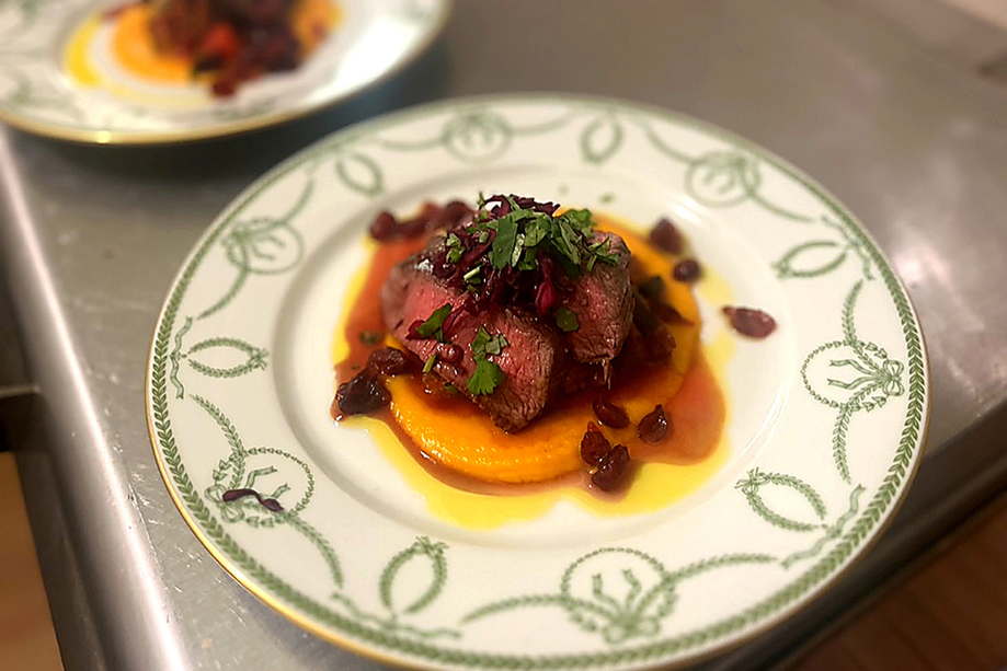 Fine dining beef course with seasonal vegetables and sauce plated by Wylie & Wood for luxury events.