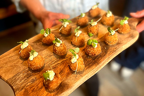 Gourmet croquettes topped with herbs and served as luxury wedding canapés by Wylie & Wood.