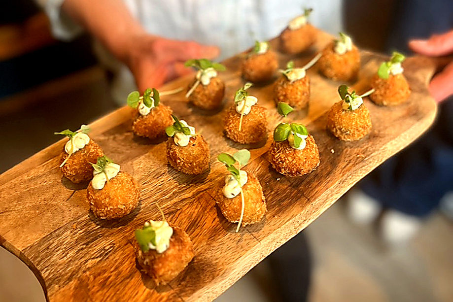 Gourmet croquettes topped with herbs and served as luxury wedding canapés by Wylie & Wood.