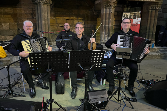 Members of The Liam Stewart Band performing live with accordion and fiddle at a Scottish wedding.