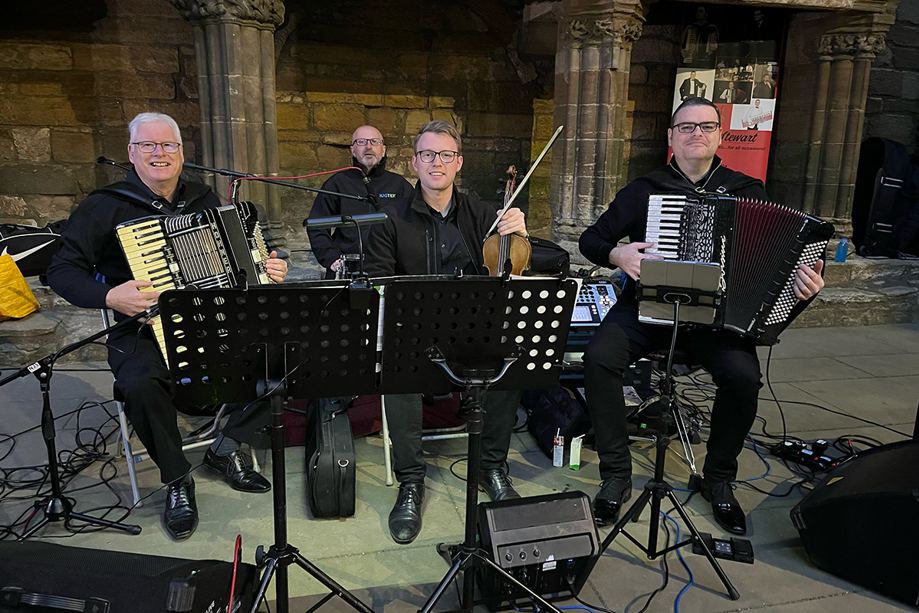 Members of The Liam Stewart Band performing live with accordion and fiddle at a Scottish wedding.
