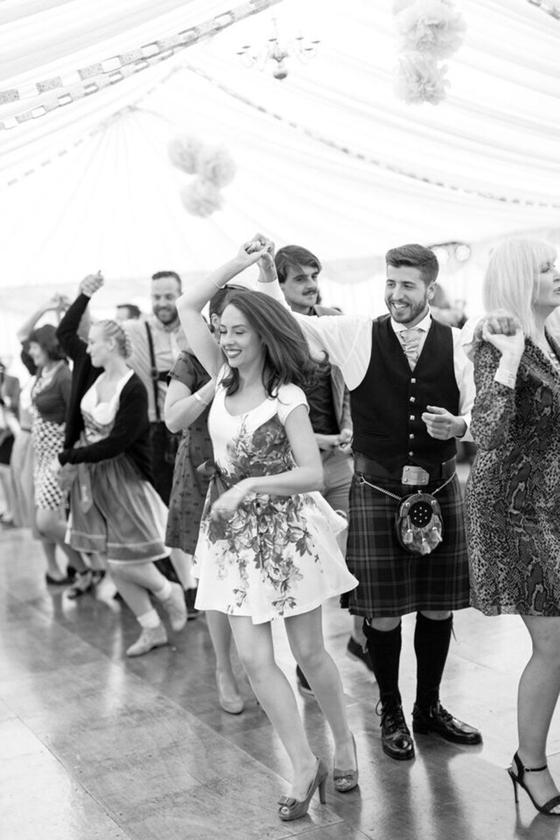 Wedding guests taking part in ceilidh dancing during a Scottish wedding reception.