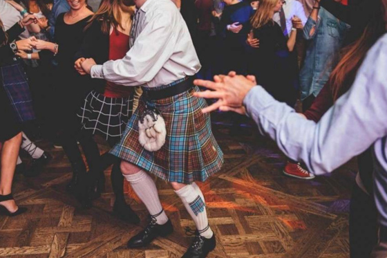Guests dancing together on a lively Scottish wedding dance floor during evening celebrations.