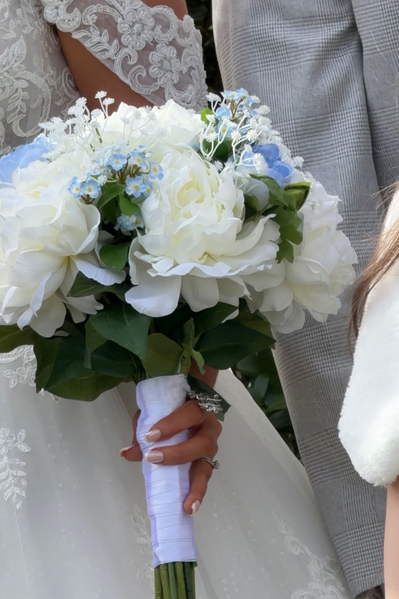 Navae Creative wedding content creator close-up of a white and blue bridal bouquet with wedding dress detail