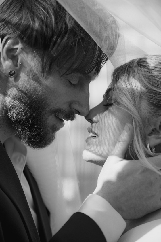 Black and white close-up wedding portrait of bride and groom under a veil by Kamila Pickles Photography