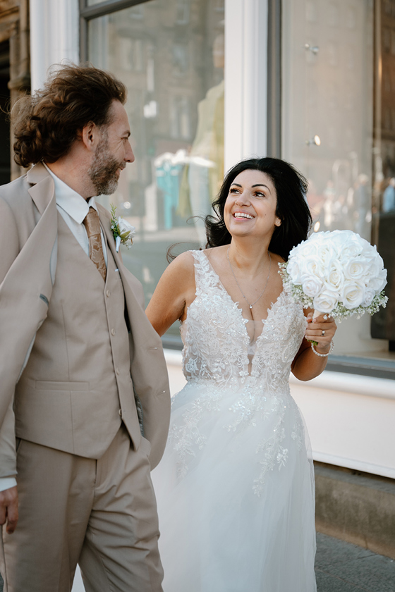 Bride and groom laughing together during city wedding portraits by Kamila Pickles Photography