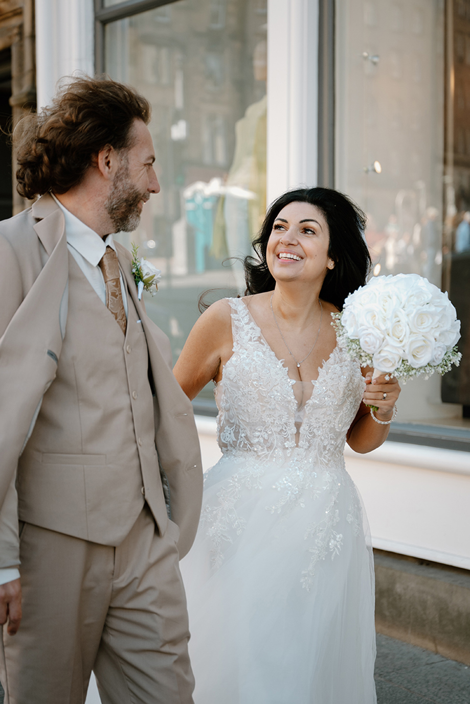 Bride and groom laughing together during city wedding portraits by Kamila Pickles Photography