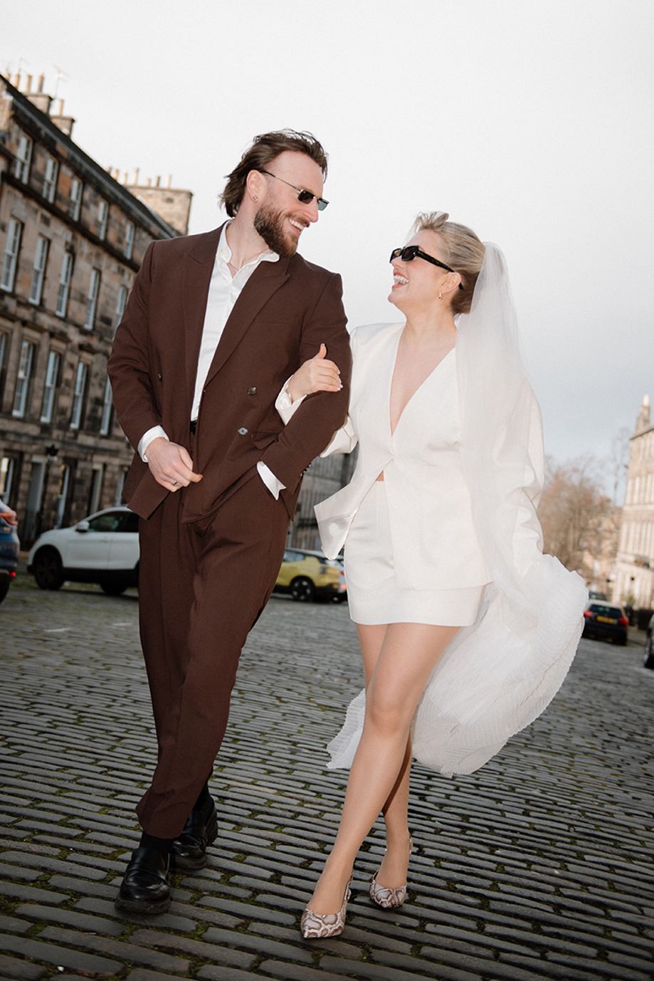 Stylish city wedding couple walking on a cobbled Edinburgh street by Kamila Pickles Photography