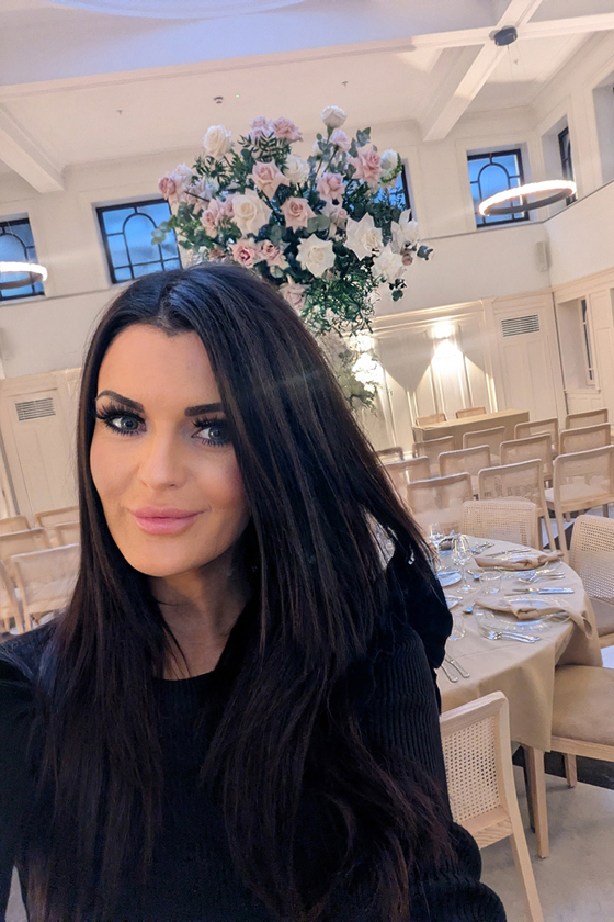 Vocals by Suzie in an elegant wedding venue with dressed tables, tall floral centrepieces and ceremony seating