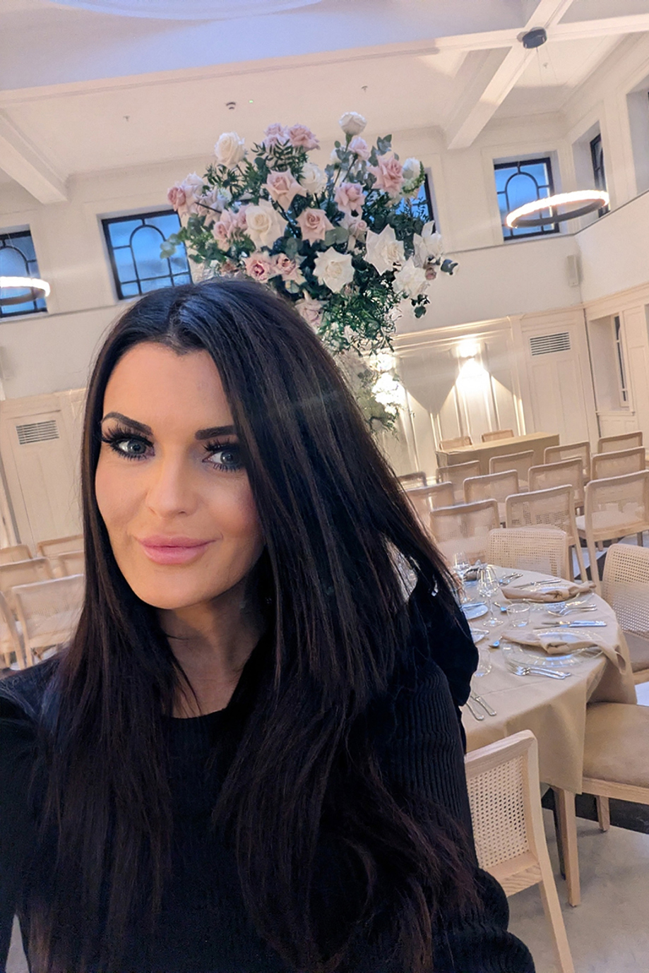 Vocals by Suzie in an elegant wedding venue with dressed tables, tall floral centrepieces and ceremony seating