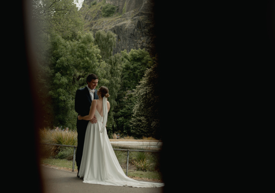 Bride and groom embracing during their natural and candid elopement wedding photoshoot in Edinburgh princes street gardens
