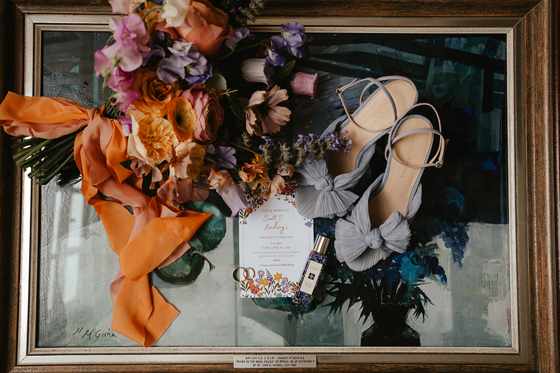 Wedding detail flat lay with orange and purple bridal bouquet by Agapanthus Flower Studio