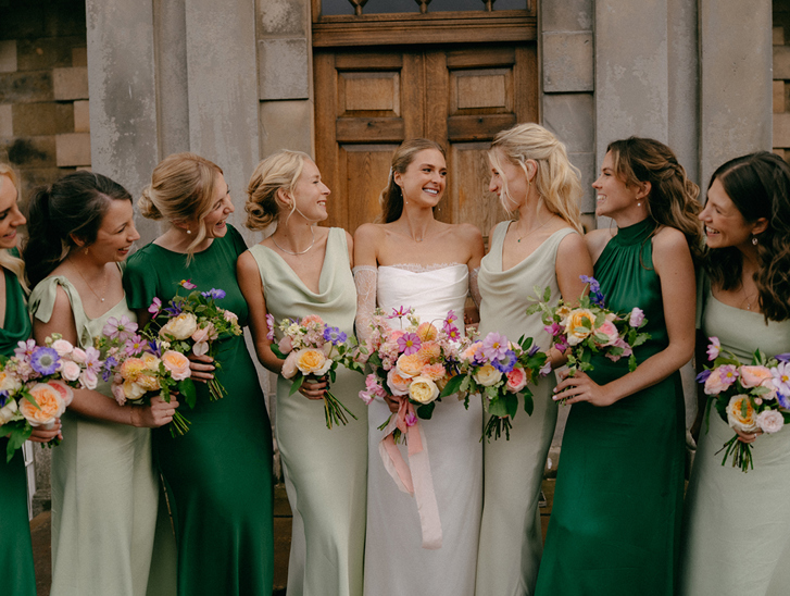 Bride and bridesmaids in green dresses holding colourful bouquets by Agapanthus Flower Studio