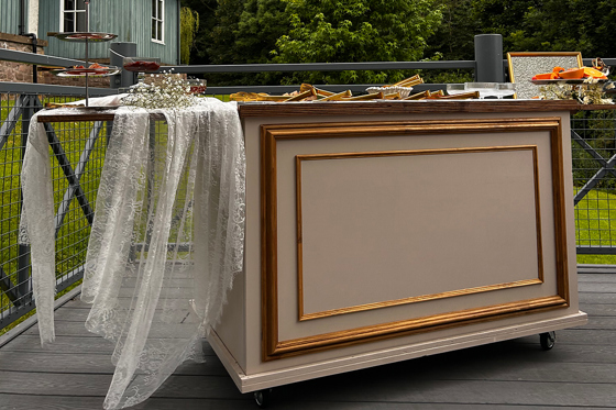 Bramble & Brie wedding grazing cart decorated with lace and gold detailing for an outdoor celebration