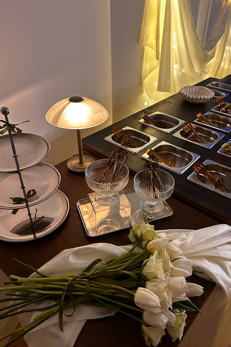 Bramble & Brie hot grazing table with gold serving dishes, glass bowls and white wedding flowers