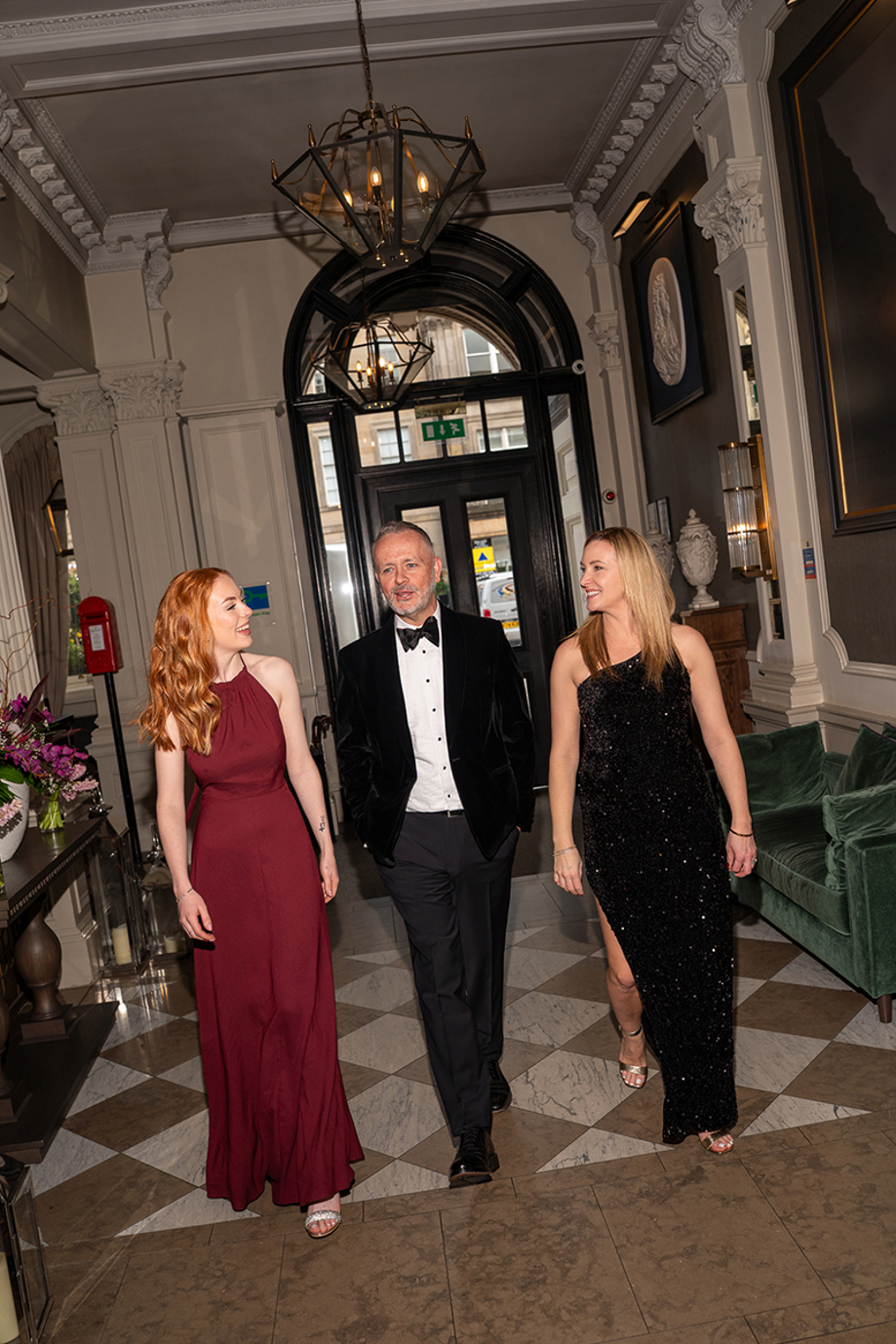 Copper Blonde wedding band trio walking together through a stylish wedding venue