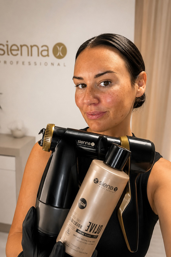 Browz & Bronze by Leah spray tanning specialist holds a Sienna X spray tan machine and professional tanning solution.