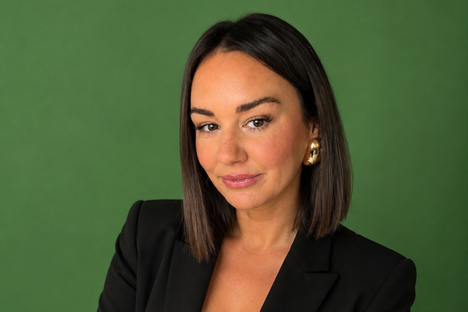 Portrait of Leah from Browz & Bronze by Leah wearing a black blazer against a green background.