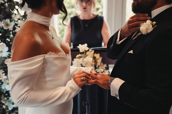 Bride places a wedding ring on the groom’s finger during a ceremony conducted by Fiona MacAlister Celebrant.