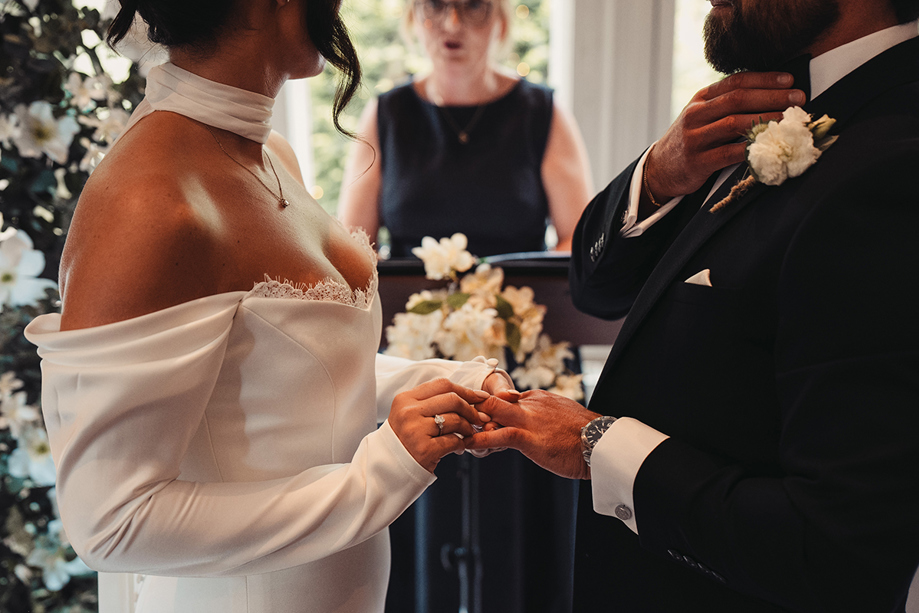 Bride places a wedding ring on the groom’s finger during a ceremony conducted by Fiona MacAlister Celebrant.