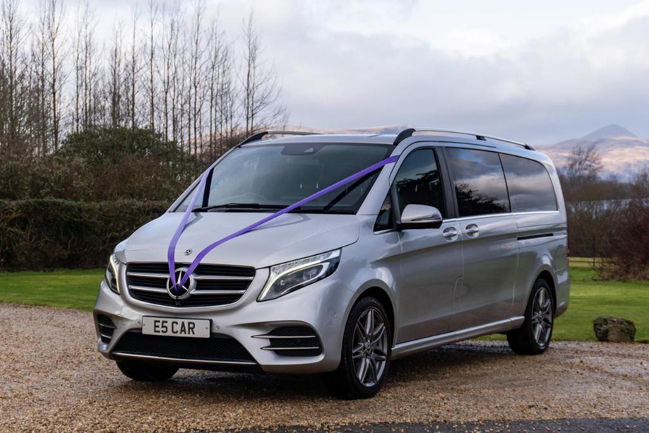 Silver Mercedes V Class with purple ribbon