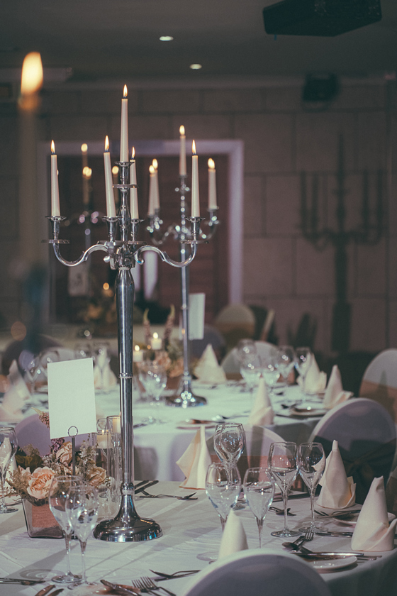 Portrait image of silver candelabra used on tables at a wedding meal in The River Inn, Renfrewshire.