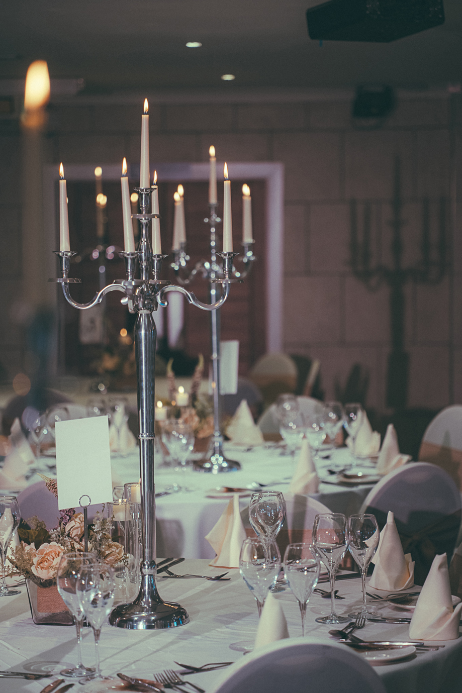Portrait image of silver candelabra used on tables at a wedding meal in The River Inn, Renfrewshire.