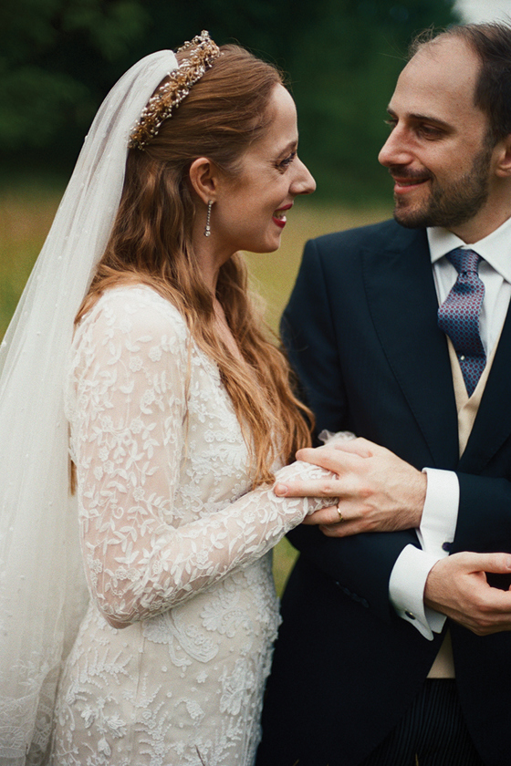 Bride smiles at her groom as he holds her hand at their Newton Don wedding.