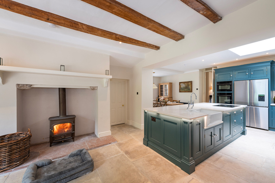 Spacious country house kitchen at Broomholm Manor with kitchen island, wood-burning stove and modern amenities.