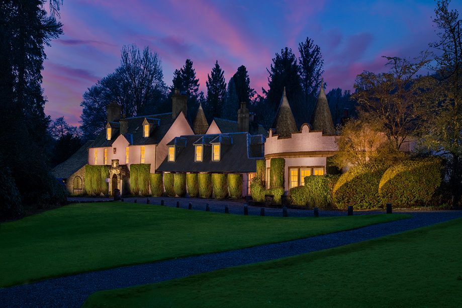 Thackray House illuminated at dusk beneath a pink and blue evening sky.
