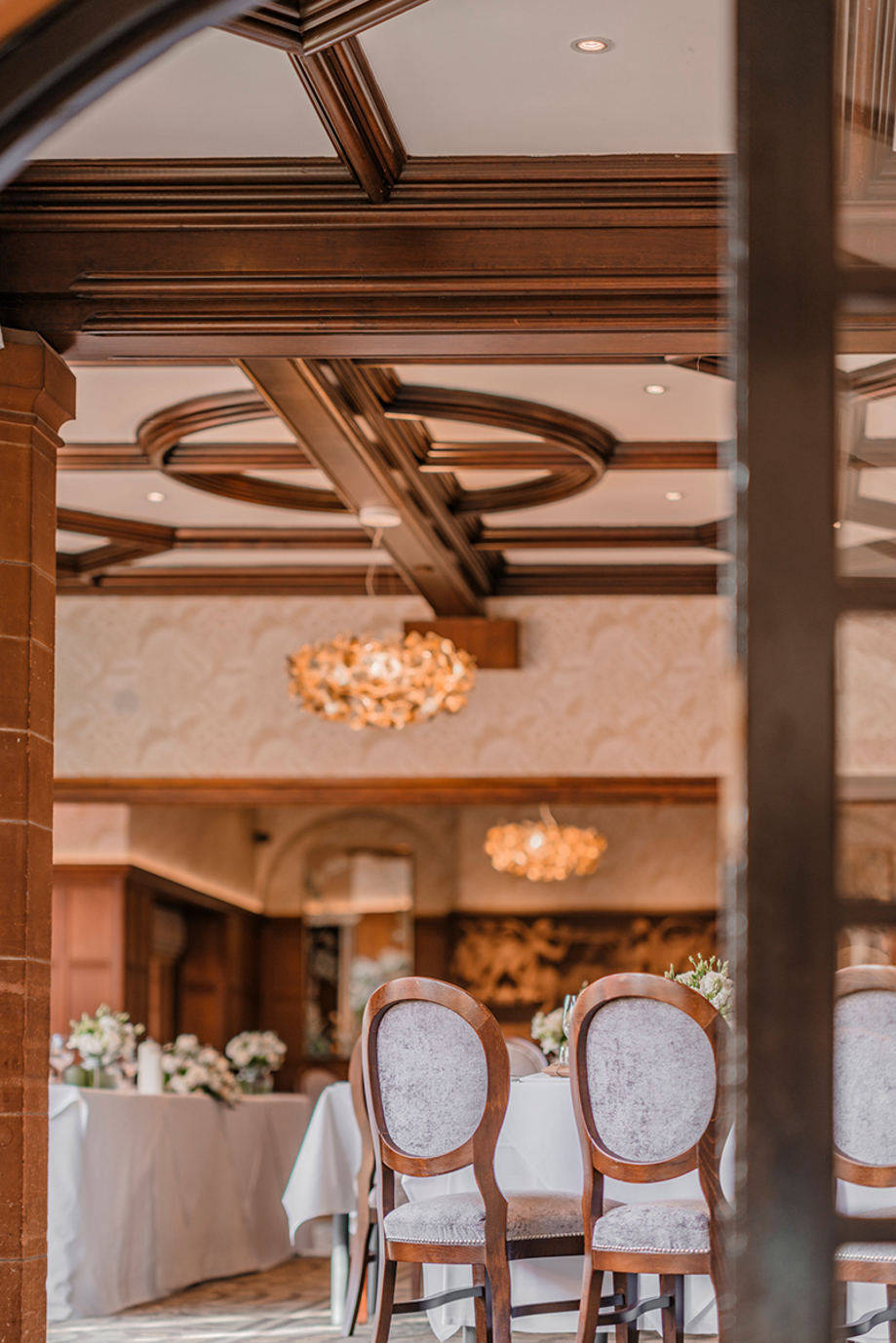 Piersland House wedding reception room set for a wedding breakfast with floral tables and upholstered chairs