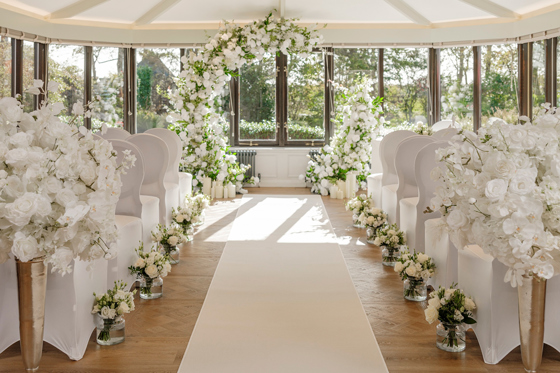 Wedding ceremony set up with white roses lining aisle