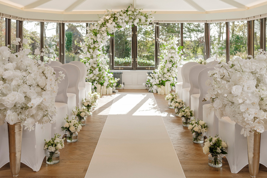 Wedding ceremony set up with white roses lining aisle