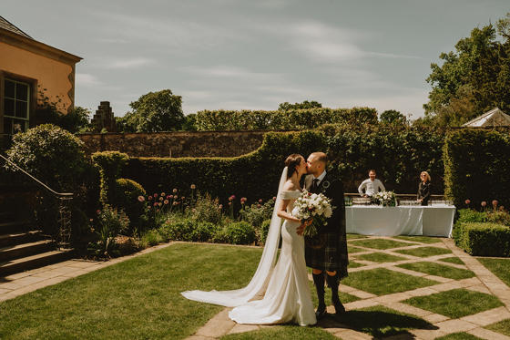 Bride and groom kissing in the gardens at Jupiter Artland wedding venue near Edinburgh