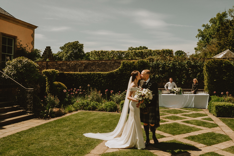 Bride and groom kissing in the gardens at Jupiter Artland wedding venue near Edinburgh