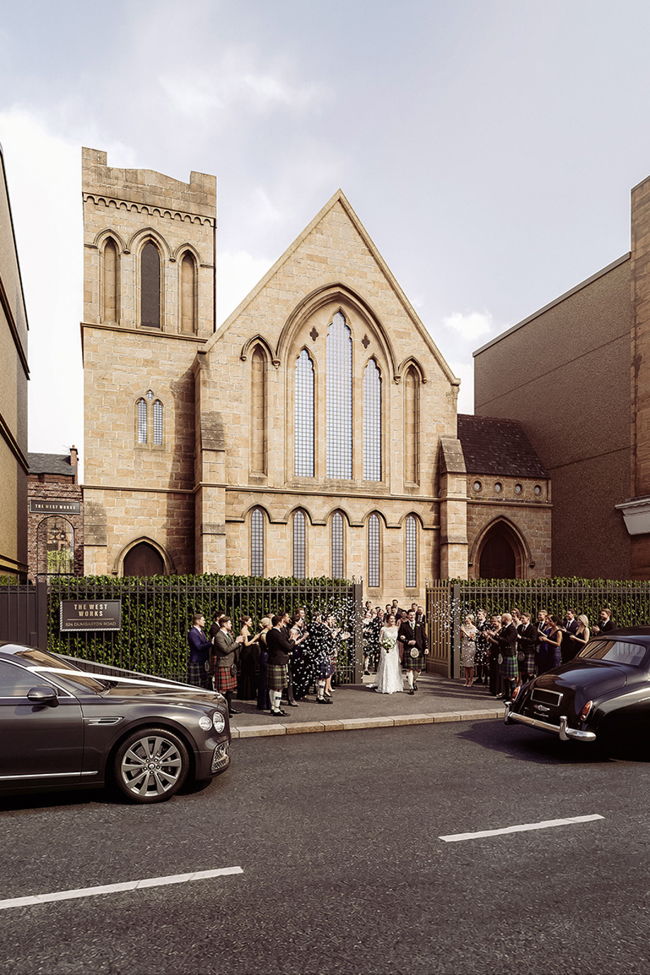 Newlyweds leaving The West Works Glasgow as wedding guests throw confetti outside the historic stone entrance