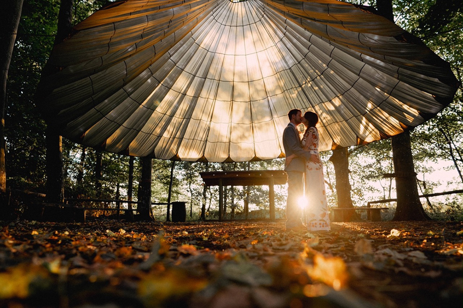 Couple kiss under tent at sunset