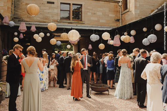 Guests in courtyard with hanging lanterns above