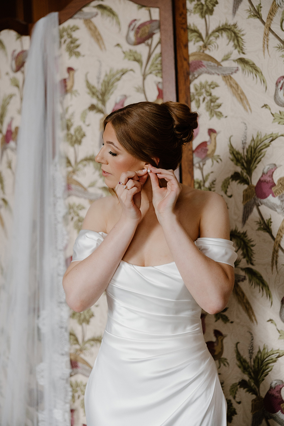 Bride fastening her earrings while getting ready for her wedding at The Edinburgh Grand.