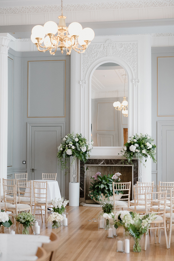Wedding ceremony setup at The Edinburgh Grand with white flowers, candles and wooden chairs.