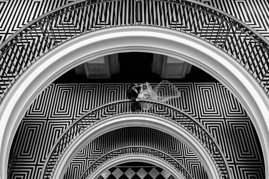 Black-and-white portrait of newlyweds on the distinctive curved staircase at The Edinburgh Grand.