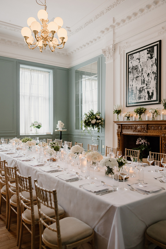 Wedding breakfast setup at The Edinburgh Grand with long white tables, candles and white floral arrangements.