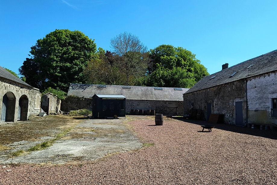 Steading courtyard at Cormiston Farm with stone buildings and clear blue skies